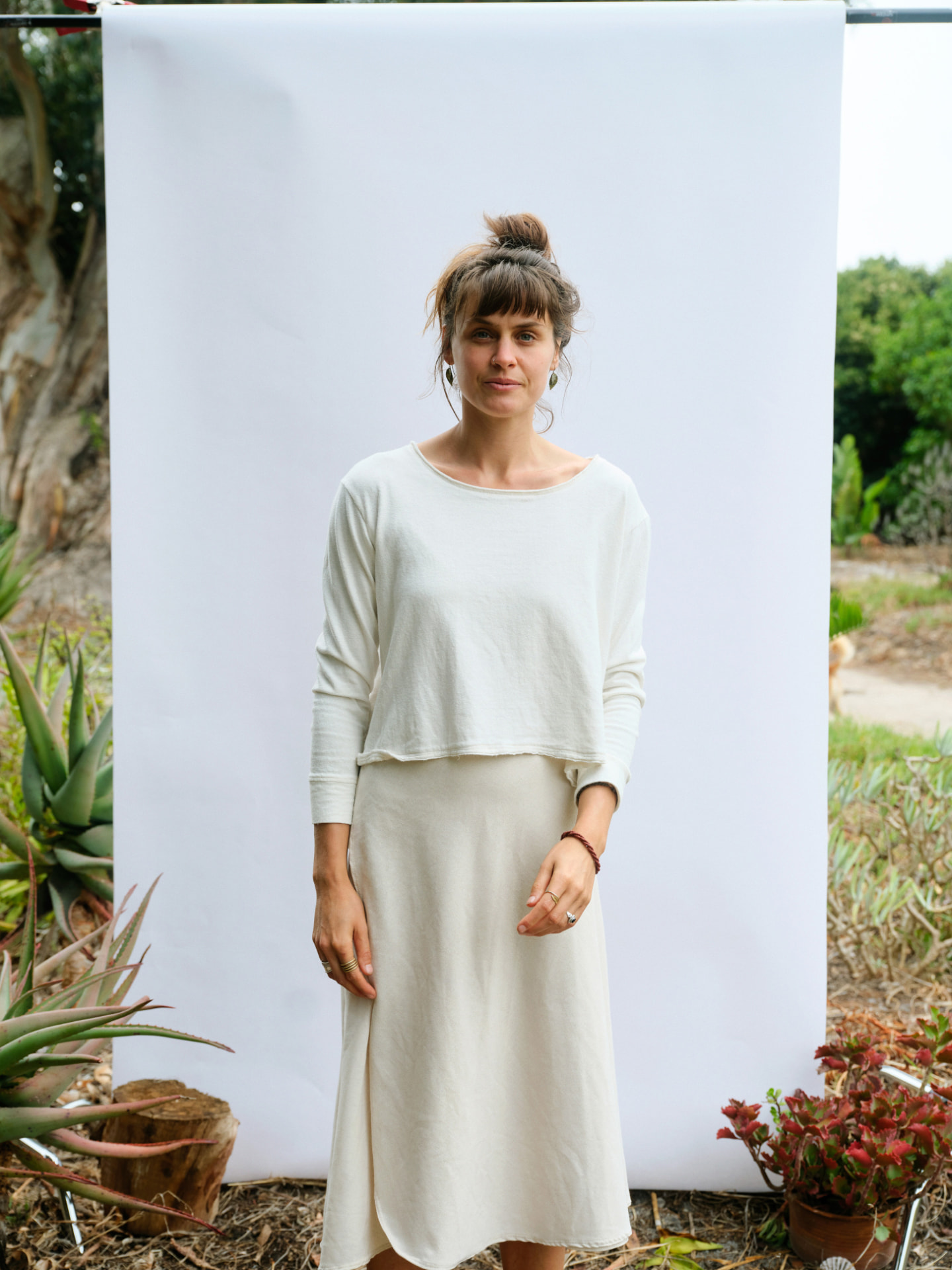 Woman wearing the Bonnie-love long sleeve T-shirt with a cream skirt, full length front view